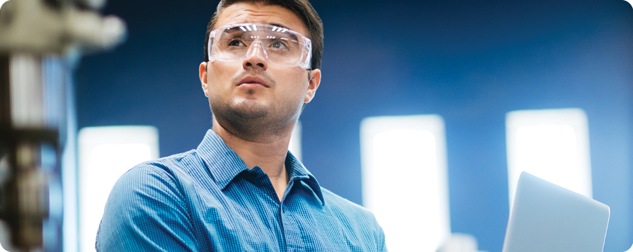 male in a blue shirt looking right with goggles on