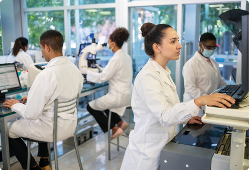 diverse groups of people in lab coats working at different computer stations